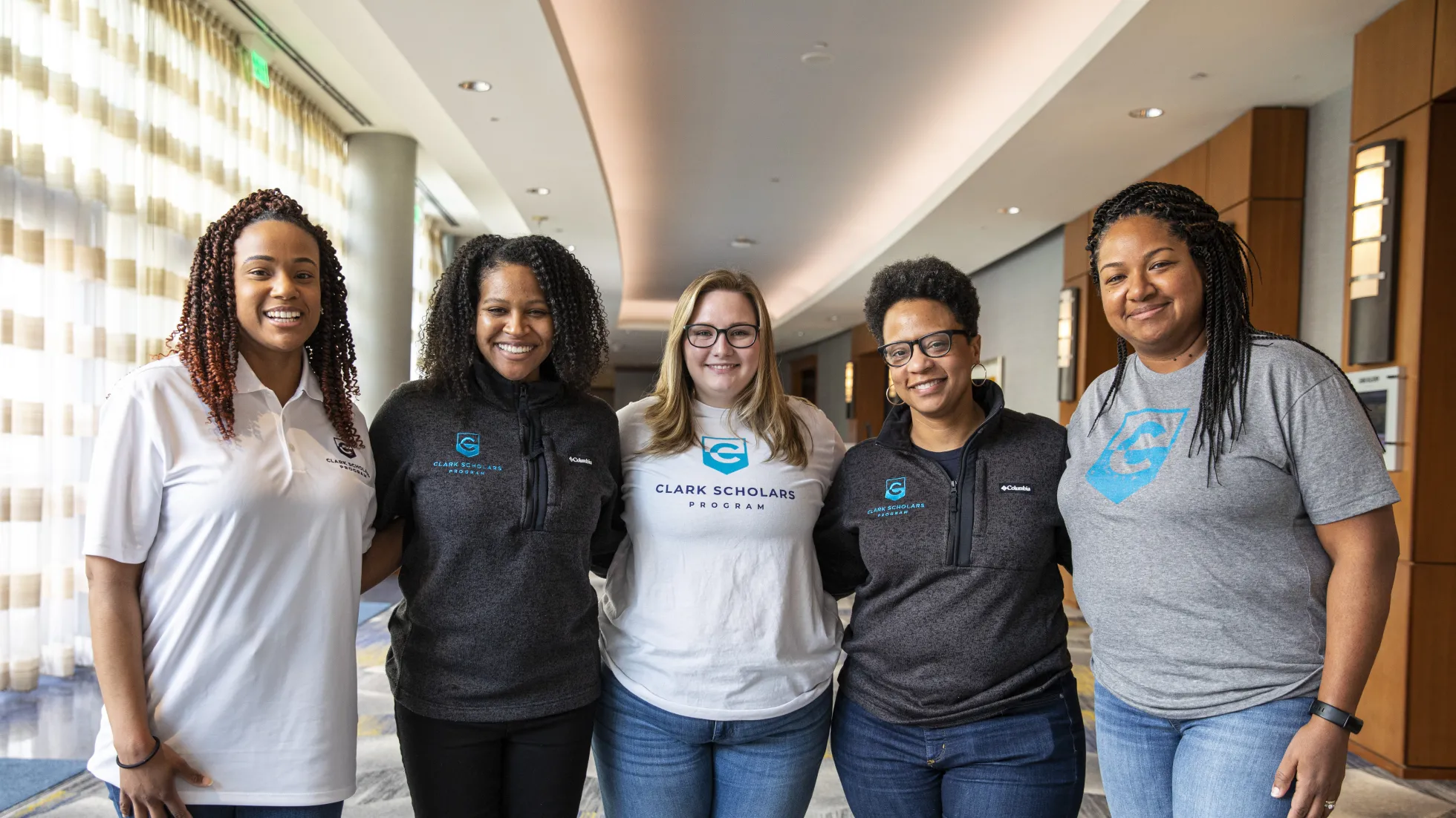 Five Clark Scholars Program Leaders stand in a group and smile. They all wear Clark Scholars Program attire.