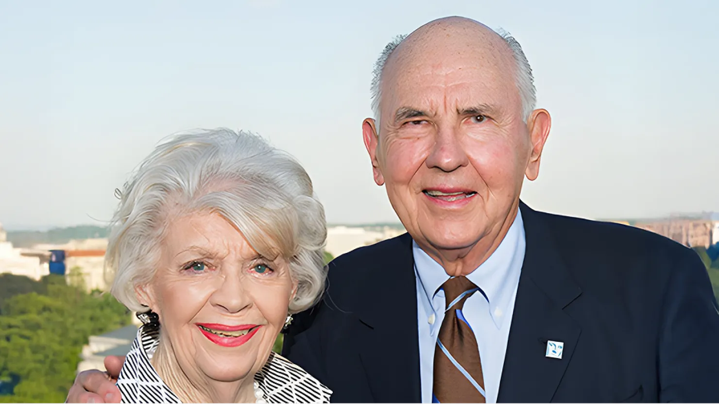 A. James and Alice B. Clark attend an outdoor celebration at GWU. The Kennedy Center and the DC skyline are in the background.