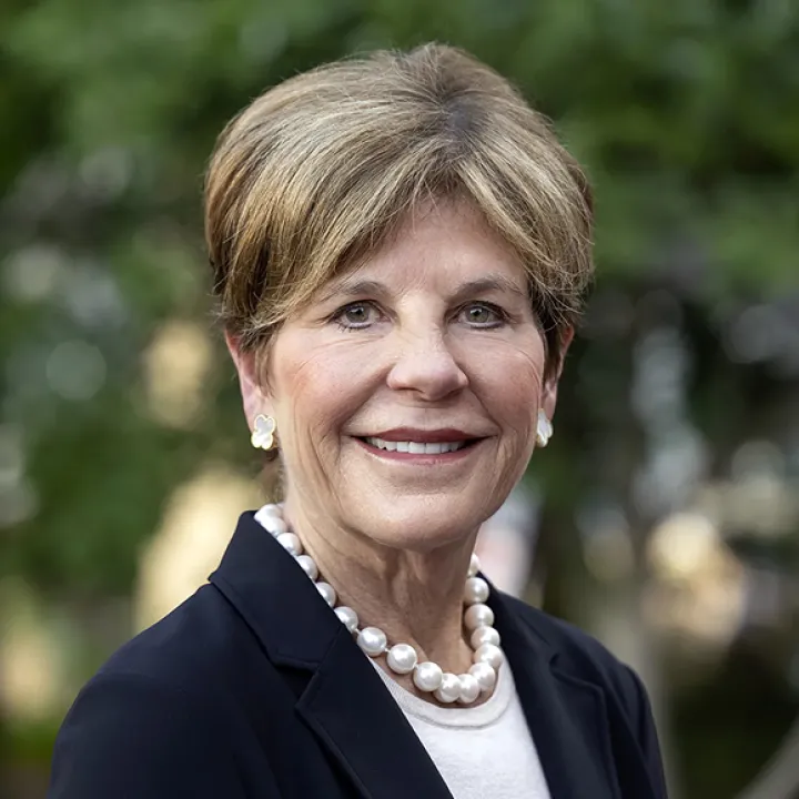 A professional headshot of Board Chair Courtney Clark Pastrick. She wears a blazer and a pearl necklace.