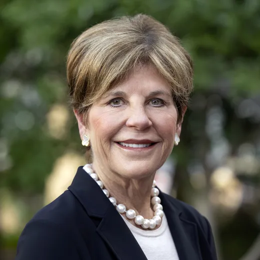 A professional headshot of Board Chair Courtney Clark Pastrick. She wears a blazer and a pearl necklace.