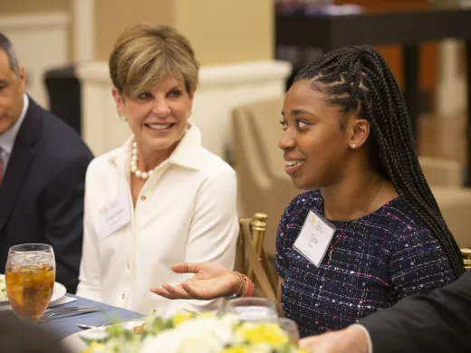 Board Chair Courtney Clark Pastrick listens to Clark Scholar speak at a university dinner.