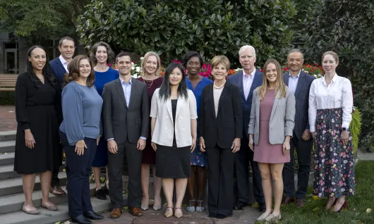 A group photo of the ten Clark Foundation staff and two board members. They stand in a park in two rows.