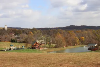 A scenic view of the Boulder Crest Virginia campus in autumn with rolling hills, colorful foliage, and a playground