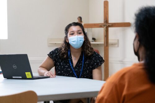 A Catholic Charities staff member provides case management to a Newcomer Network client, connecting her to social services.